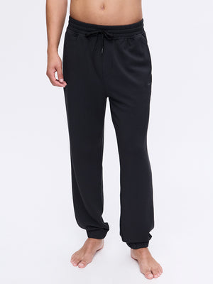 Model standing in Stratus Sweatpant in Black, featuring a relaxed fit and elastic cuffs for comfort.