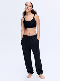 Model wearing Stratus Sweatpant in Black with relaxed silhouette and pockets, styled for lounging.