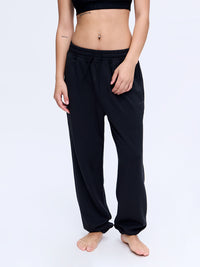 Model standing in Stratus Sweatpant in Black, with the relaxed silhouette and soft fabric.