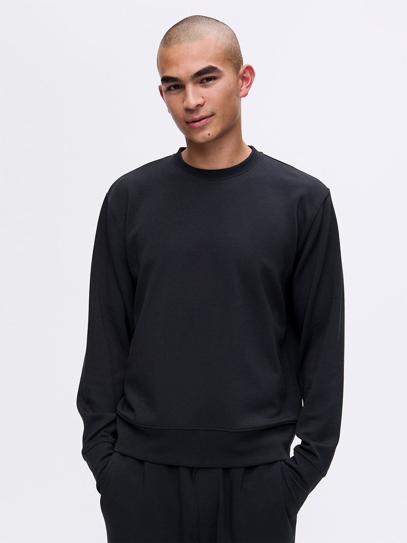 Model wearing Stratus Sweatshirt in Black, featuring a relaxed fit and ultra-soft fabric for comfort.