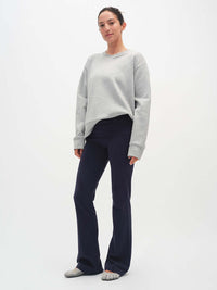 Model standing in Flared Legging in Navy, extra-tall waistband providing customizable fit.