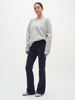Model standing in Flared Legging in Navy, extra-tall waistband providing customizable fit.