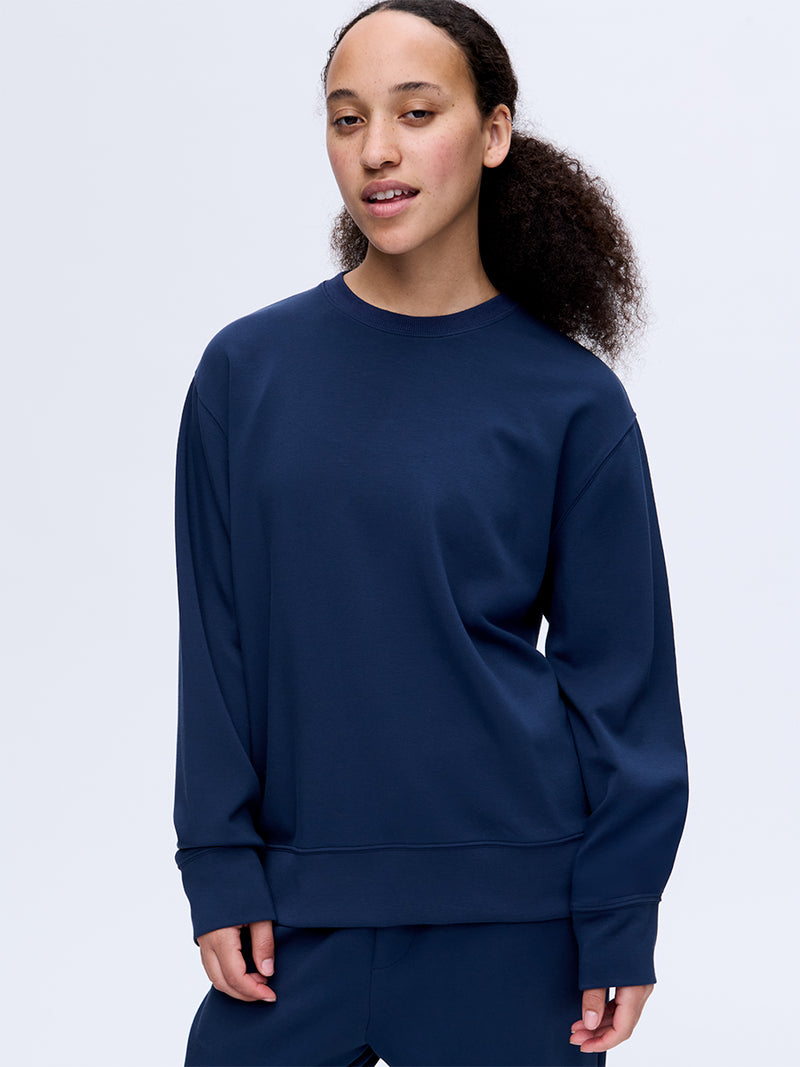 Model wearing Stratus Sweatshirt in Navy, with a relaxed fit for comfort and warmth.