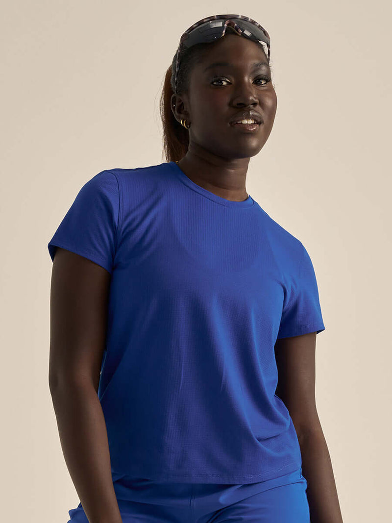 Model wearing ThinkFast Mesh Shortsleeve in vibrant blue, showing cooling fabric and relaxed fit.