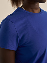 Close-up of model wearing ThinkFast Mesh Shortsleeve in Blue, featuring breathable fabric for moisture management.