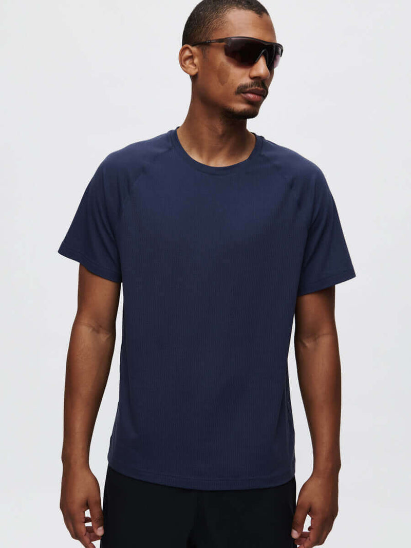 Model wearing ThinkFast Mesh Shortsleeve in Navy, featuring a classic fit and cooling fabric for activewear.