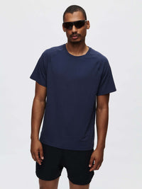 Model standing confidently in ThinkFast Mesh Shortsleeve in Navy, featuring a classic fit and cooling technology.