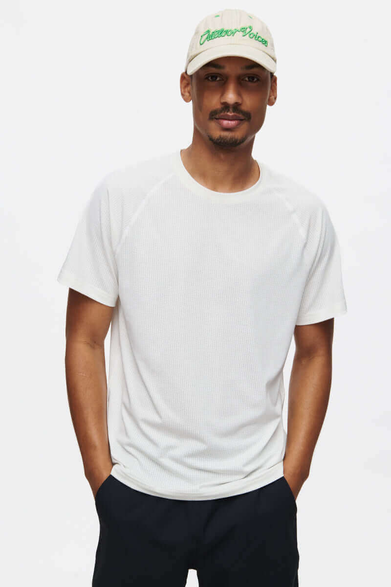 Model wearing ThinkFast Mesh Shortsleeve in White, featuring cooling technology for active performance.