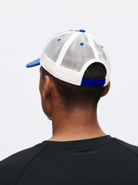 Back view of a man wearing a Doing Things Trucker Hat with blue details and mesh for breathability.