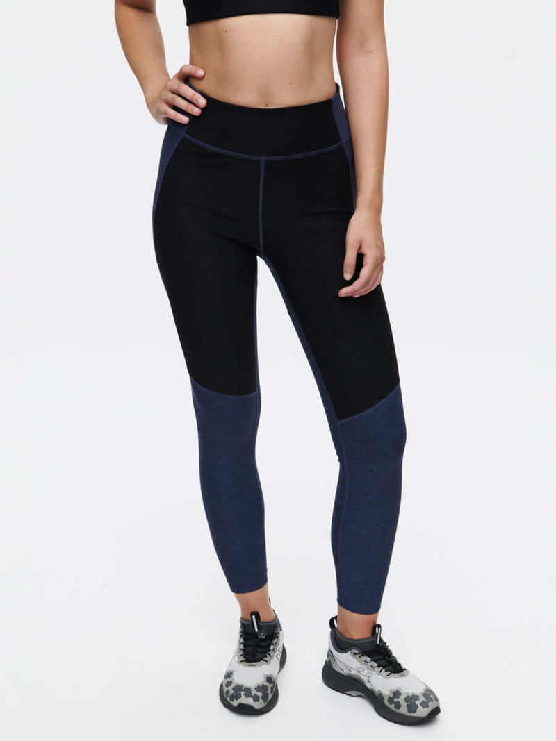 Model wearing Two Tone 7/8 Legging in black and navy, featuring two-tone paneling and a flattering fit.