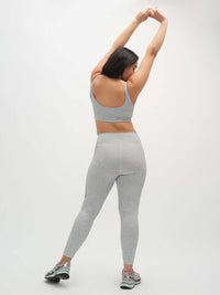 Model stretching in Two Tone 7/8 Legging, featuring 2-tone paneling and a fitted design for activewear.