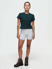Model standing in Waffle Baby Tee in Forest Green, made of soft cotton with a fitted style.