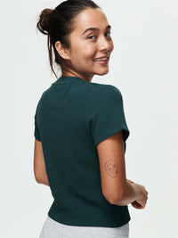 Back view of model wearing Waffle Baby Tee in Forest Green, showing fitted style and short sleeves.