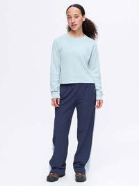 Model standing in light blue Waffle Longsleeve with soft cotton fabric, paired with navy pants, ready for lounging.