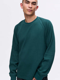 Model posing in Waffle Longsleeve in Deep Teal, featuring a relaxed fit and waffle knit texture.