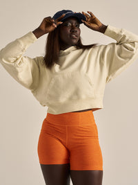 Model posing in Warmup 5" Short in Orange, with the sculpting fit and textured fabric.