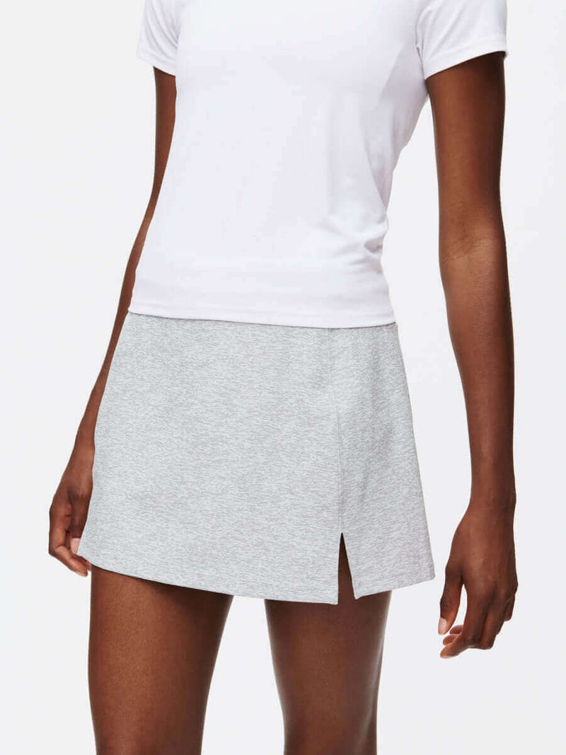 Model wearing Warmup 2.5" Skort in Heather Grey, featuring a stylish front slit for breathability.