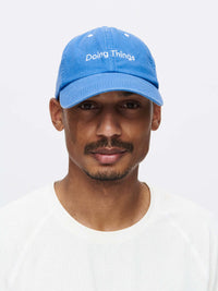 Man wearing Washed Hat in Blue, featuring embroidered 'Doing Things' logo and classic design.