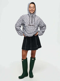 Model smiling in Windbreaker with plaid print, featuring a hood and relaxed fit, styled for everyday wear.