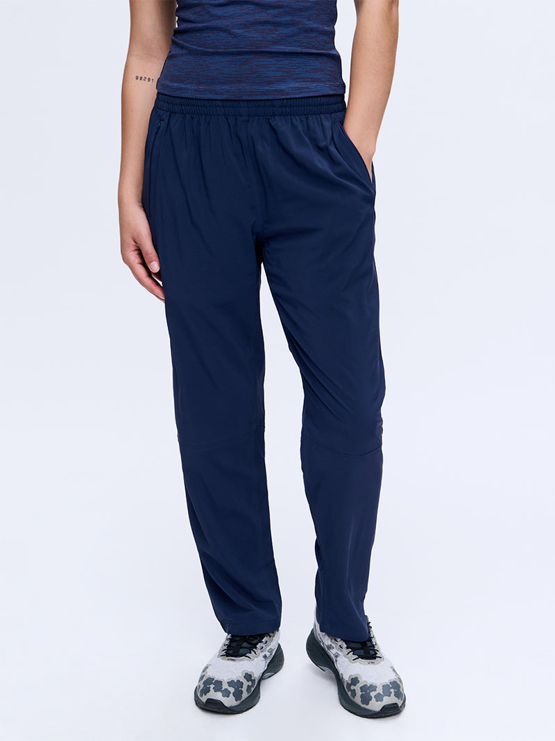 Model standing in Zephyr 26" Pant in Navy, featuring a drawstring waist and lightweight fabric for everyday wear.