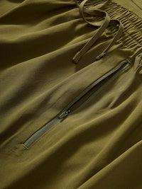 Detail view of Zephyr 26" Pant in Olive, featuring a zippered pocket and adjustable drawstring waist.