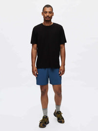 Model standing in black t-shirt and Zephyr 5" Short in blue, featuring a custom-fit drawstring waist.
